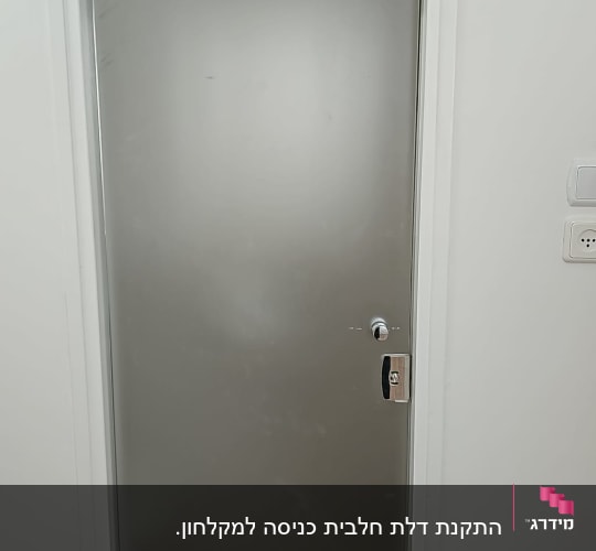 דלת זכוכית עם מסגרת לבנה וקיר לבן